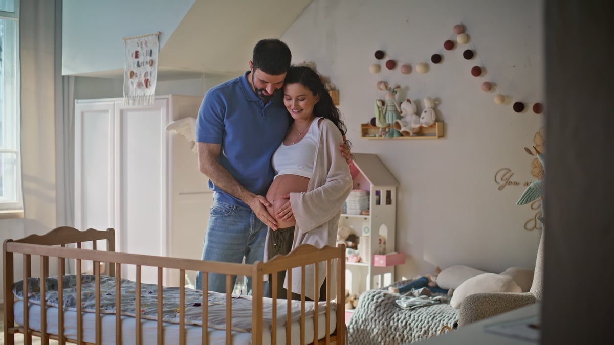 Expectant parents together in a cosy nursery